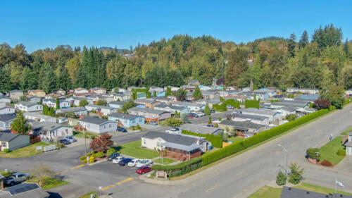 An aerial view of a rv park with trees in the background.