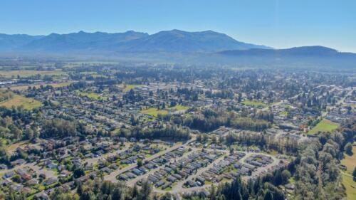 An aerial view of a town with trees and mountains.