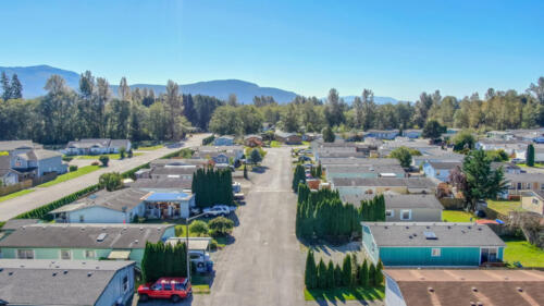 An aerial view of a rv park with trees in the background.