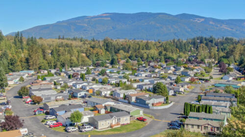 An aerial view of a rv park with mountains in the background.